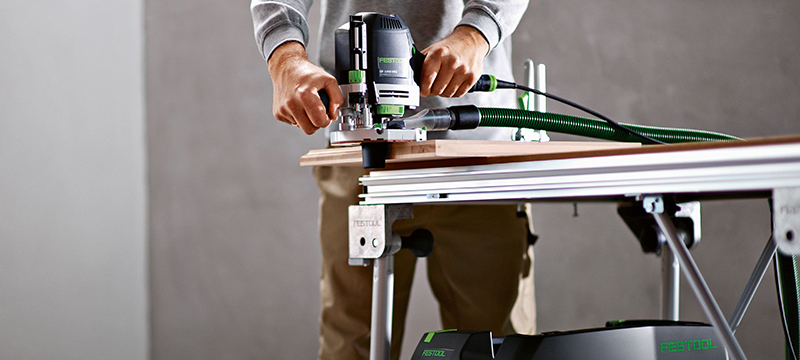 A worker uses a Festool sander with a Festool dust extractor