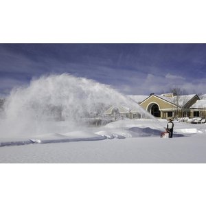 Person operating a snow blower on a clear winter day