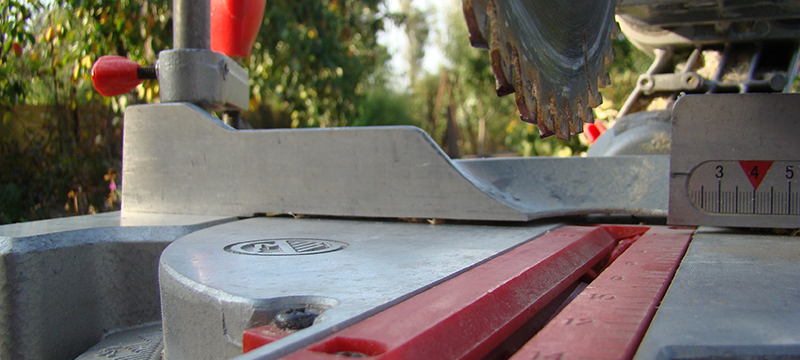 A miter saw sits dusty shortly after a cut.