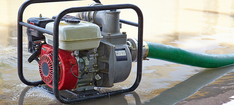 A Honda water pump is used to clear standing water.