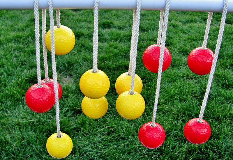 Red and Yellow golf balls that have been drilled to make a ladder golf game.