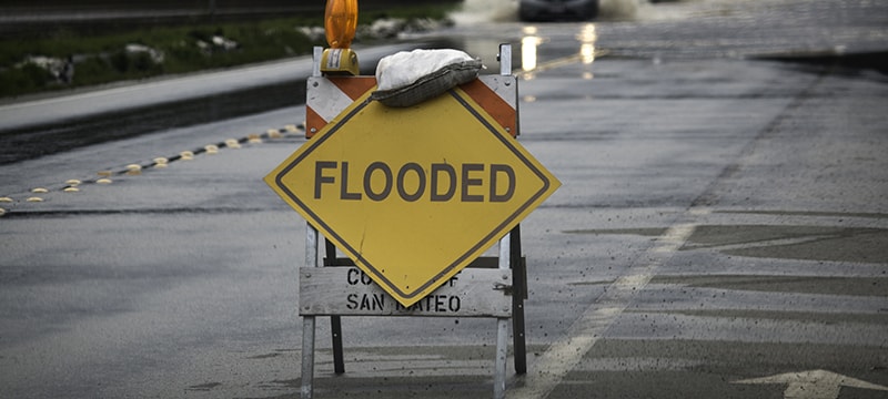Flooded sign blocking off roadway