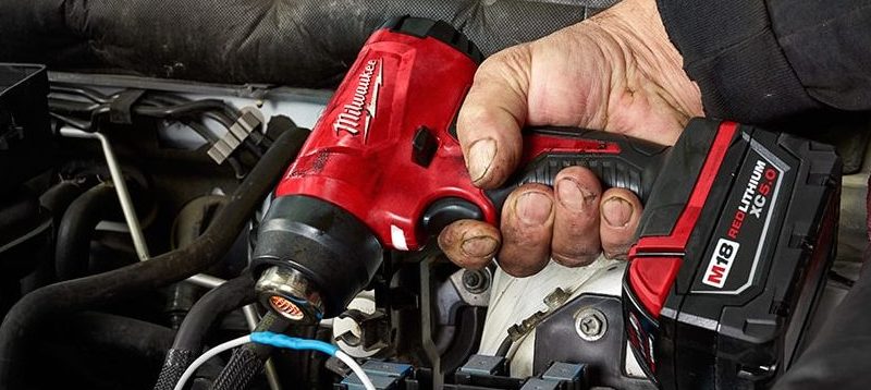 Milwaukee 2688-21 m18 cordless heat gun shrinking shrink wrap around some wires on a car engine