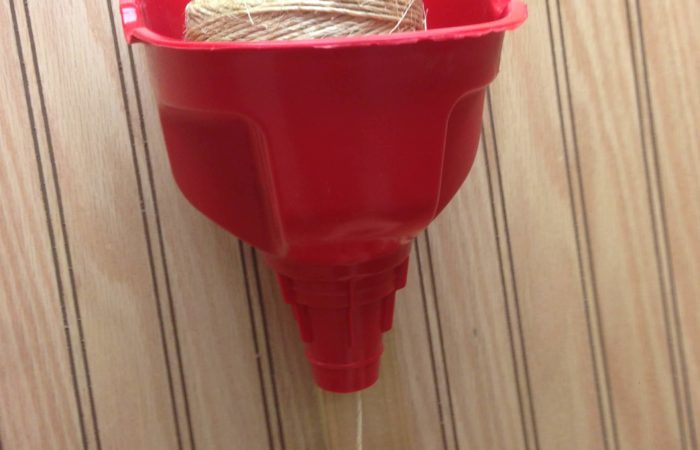 Fasten a funnel to a wall and insert a ball of twine. The twine can be pulled from the bottom of the funnel keeping it organized.