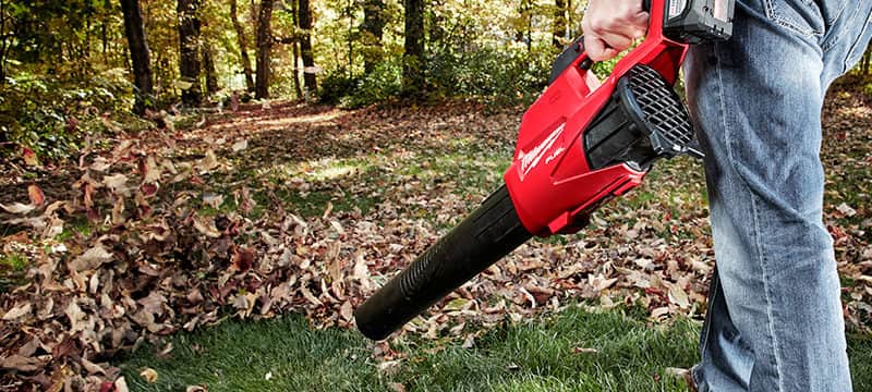 Homeowner using a Milwaukee Blower in their yard.