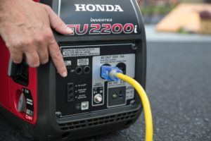 Person changing the Eco Throttle Switch to On with the Honda EU2200i Generator