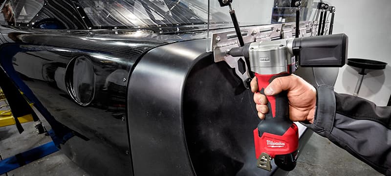 Milwaukee Rivet Gun installing rivets on the back of a race car.