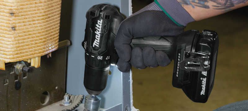 Makita cordless drill being used with a socket to level a washing machine