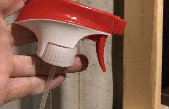 Use a spray bottle handle to remove standing water from a pipe