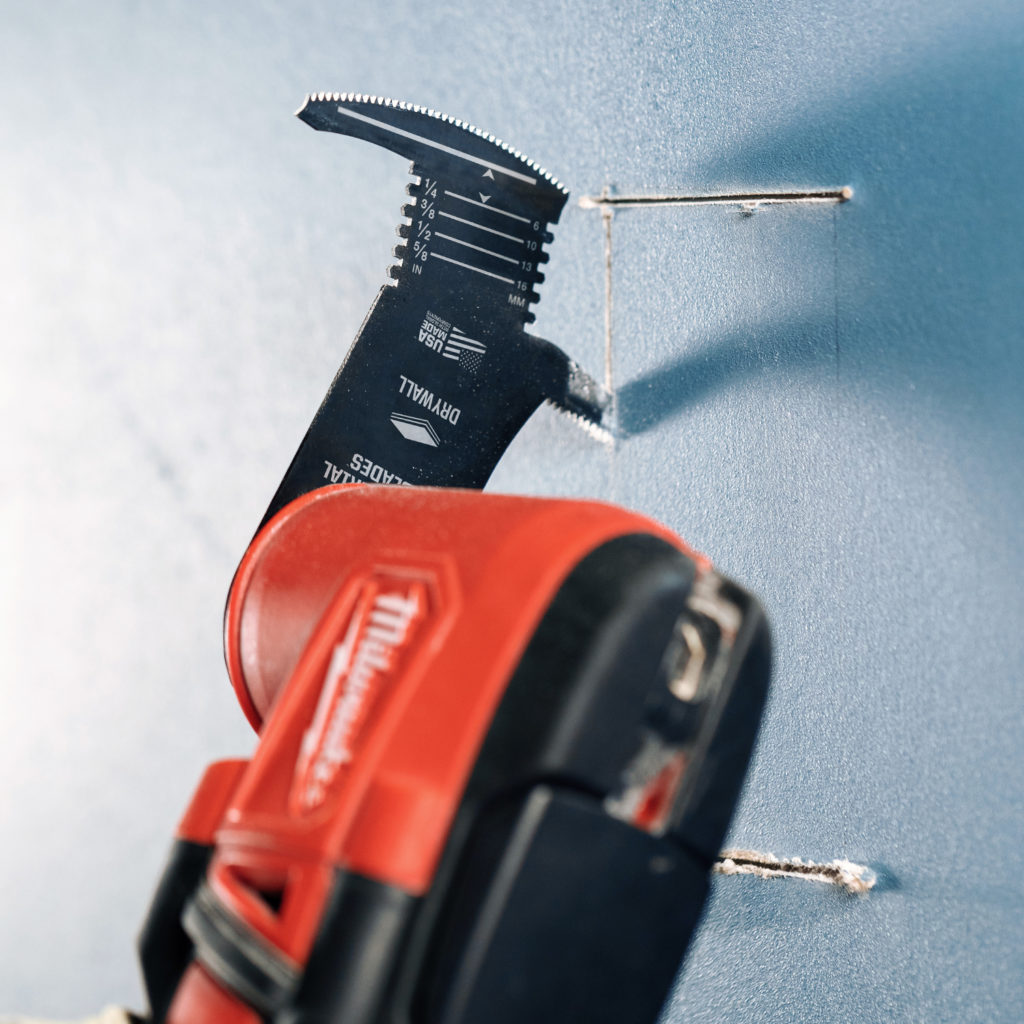 Milwaukee oscillating multi tool using an imperial blades drywall cutting blade to cut through drywall