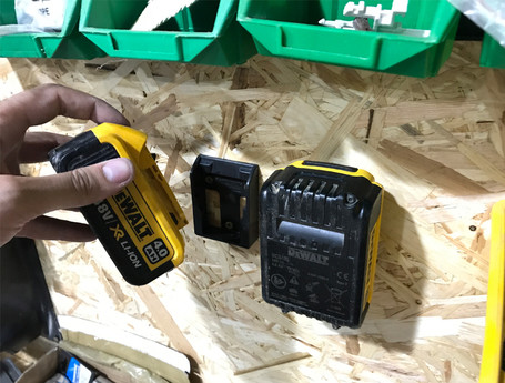 A worker puts a DEWALT battery into a StealthMounts battery clip.