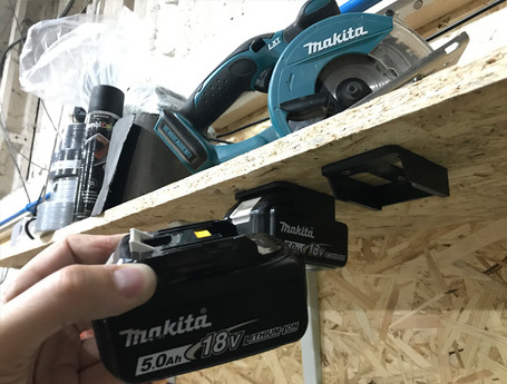 A worker puts a Makita battery on a StealthMounts battery clip.