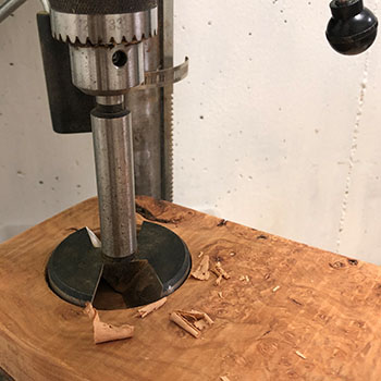 Drill pressing cutting a clock sized hole to make a wood clock.