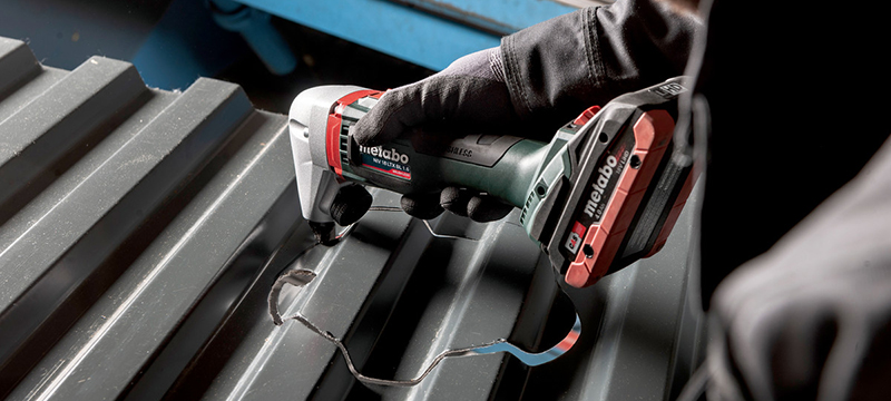 A worker cuts a piece of sheet metal with the Metabo 18 Volt Cordless Nibbler