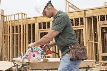 A worker uses a SKILSAW to cut a two-by-four on the jobsite.