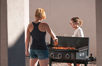 A woman cooks on a 36-inch Blackstone griddle.