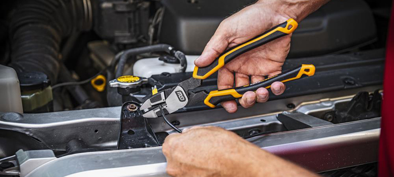 A GEARWRENCH lineman pliers is used to cut a wire under the hood of a car.
