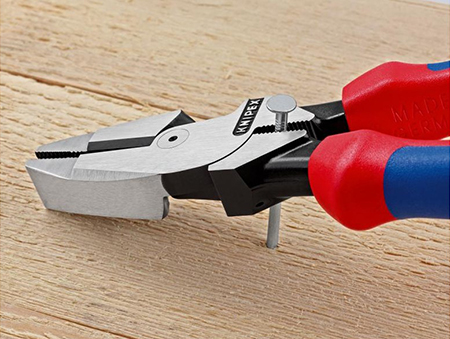 A Knipex lineman pliers is use to pull a ail out of a board.