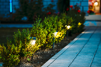 Small lanterns light a walkway up to a home.