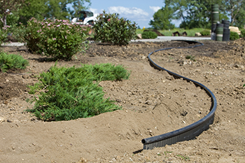 Plastic edging is installed before a flower bed is finished.