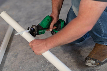 A PVC pipe is cut using the Metabo HPT MultiVolt Reciprocating Saw.