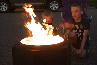 Kids roast marshmallows around a Dragonfire Smokeless Fire Pit.