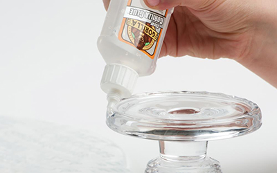 Clear Gorilla Glue is applied to a glass serving dish.