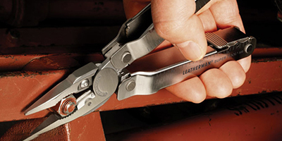 A Leatherman Super Tool 300 is used to tighten a bolt.