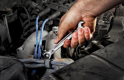 A mechanic uses a Milwaukee Ratcheting Wrench to tighten a bolt.