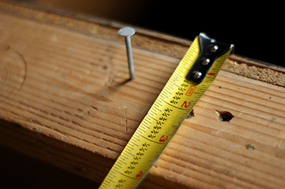 A standard tape measure is used to measure a wall stud.