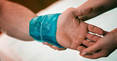 An ice pack is applied to a wrist to help the person cool off.