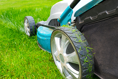 A lawnmower cuts through grass.