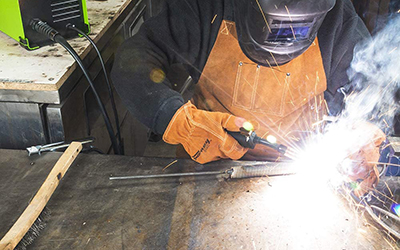 A Forney industries Easy Weld 261 140 FC-i MIG Welder is used to join two pieces of metal.