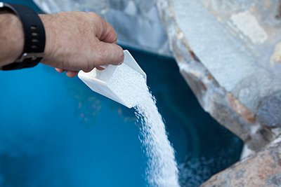 Chemicals are added to a swimming pool.