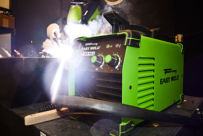 A welder uses a Forney Easy Weld 140 FC-i Flux-Core wire welder.