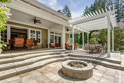 A white pergola covers a patio table and chairs.