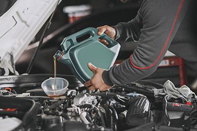 Engine oil is poured into a vehicle engine.