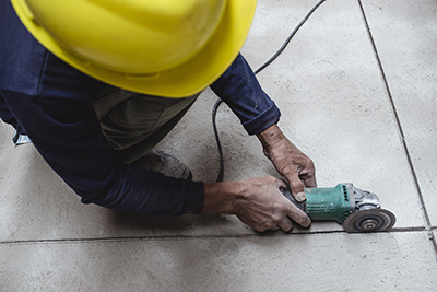 An angle grinder is used to score concrete.