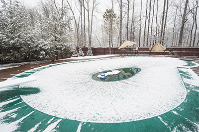 A cover over an inground swimming pool during winter.