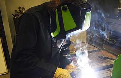 A welder wears a Forney Easy Weld Series ADF Welding Helmet while working.