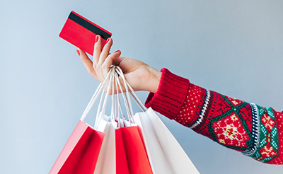 Holiday shopper holds out a credit card.