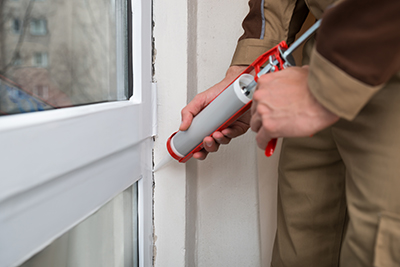 Person Hands Applying Silicone Sealant With Caulking Gun