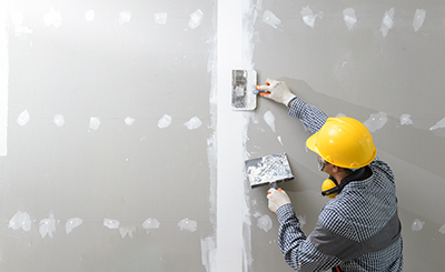 Drywall mud is applied to a joint of two pieces of drywall.