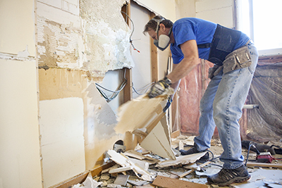 Drywall is removed from wall studs.