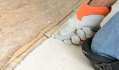 Person using utility knife to cut carpet