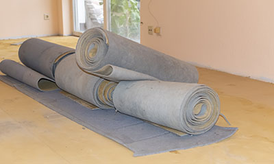 Carpet leftovers in a living room after being removed to lay a new floor covering.