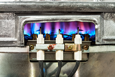 A flame burns in a natural gas water heater.