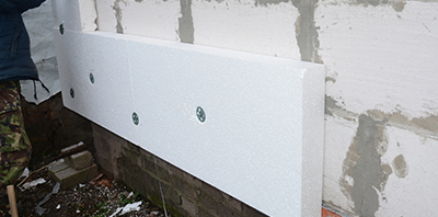 Rigid foam insulation is mounted to a wall.