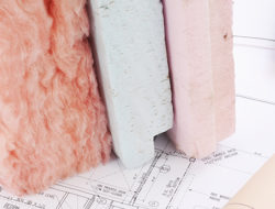 Different types of insulation sit on top of blueprints