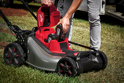 Two M18 REDLITHIUM HIGH OUTPUT HD12.0 Ah batteries are loaded into the Milwaukee M18 FUEL Self-Propelled Dual Battery Mower.